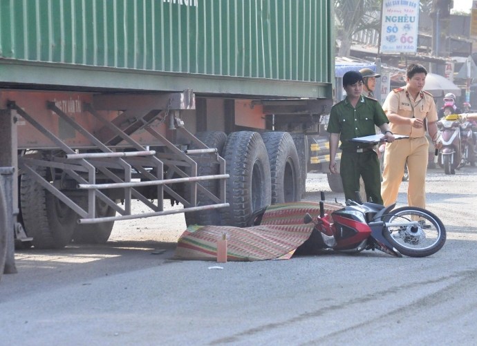 nguoi phu nu chet tham duoi gam xe container